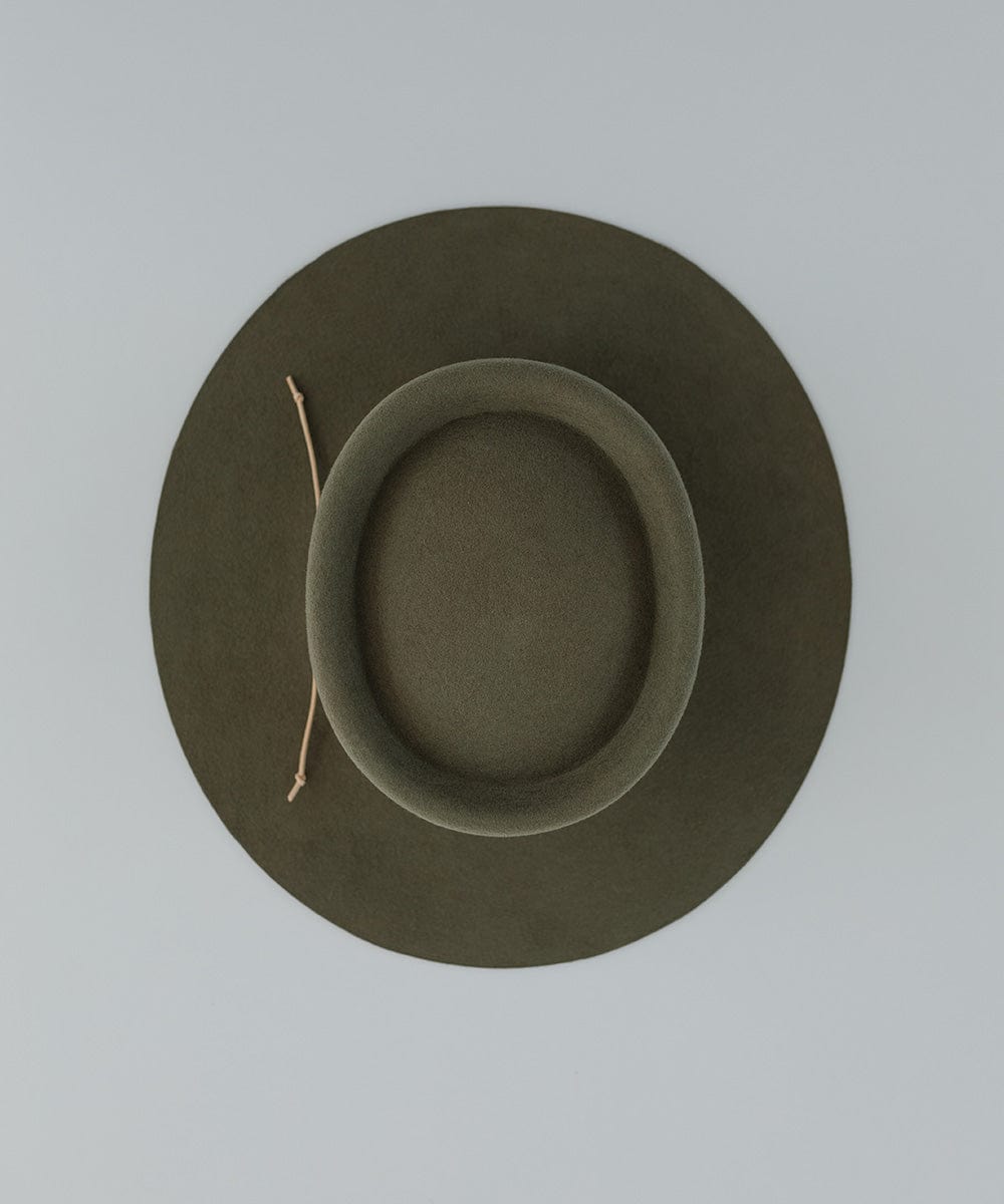 An olive hat with a cream suede band on a plain background #color_cream