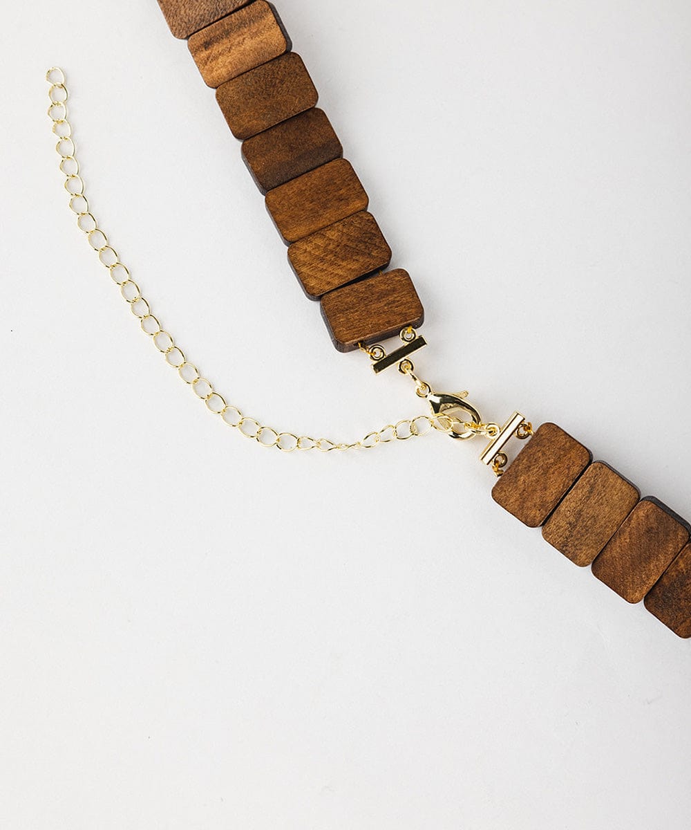 A brown wooden beaded band on a plain background #color_brown