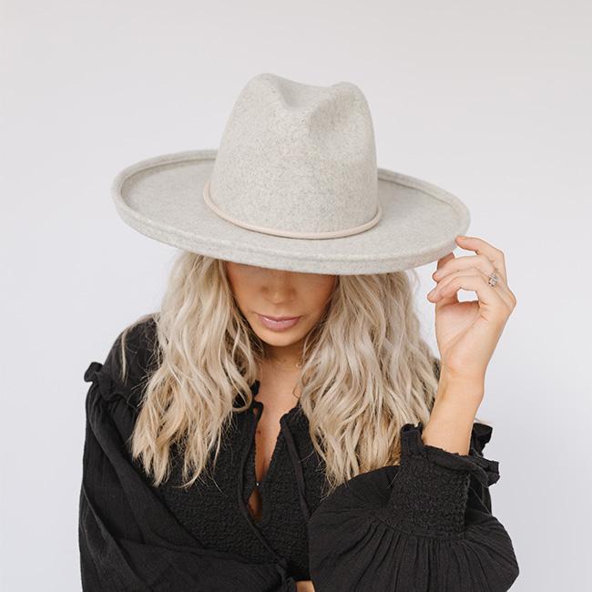 Woman wearing a heather grey pencil brim fedora hat and a black top against a plain background #color_heather grey