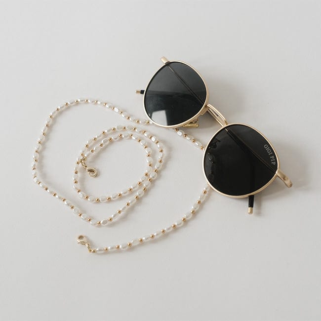 Sunglasses with a gold pearl chain strap on a plain background #color_gold