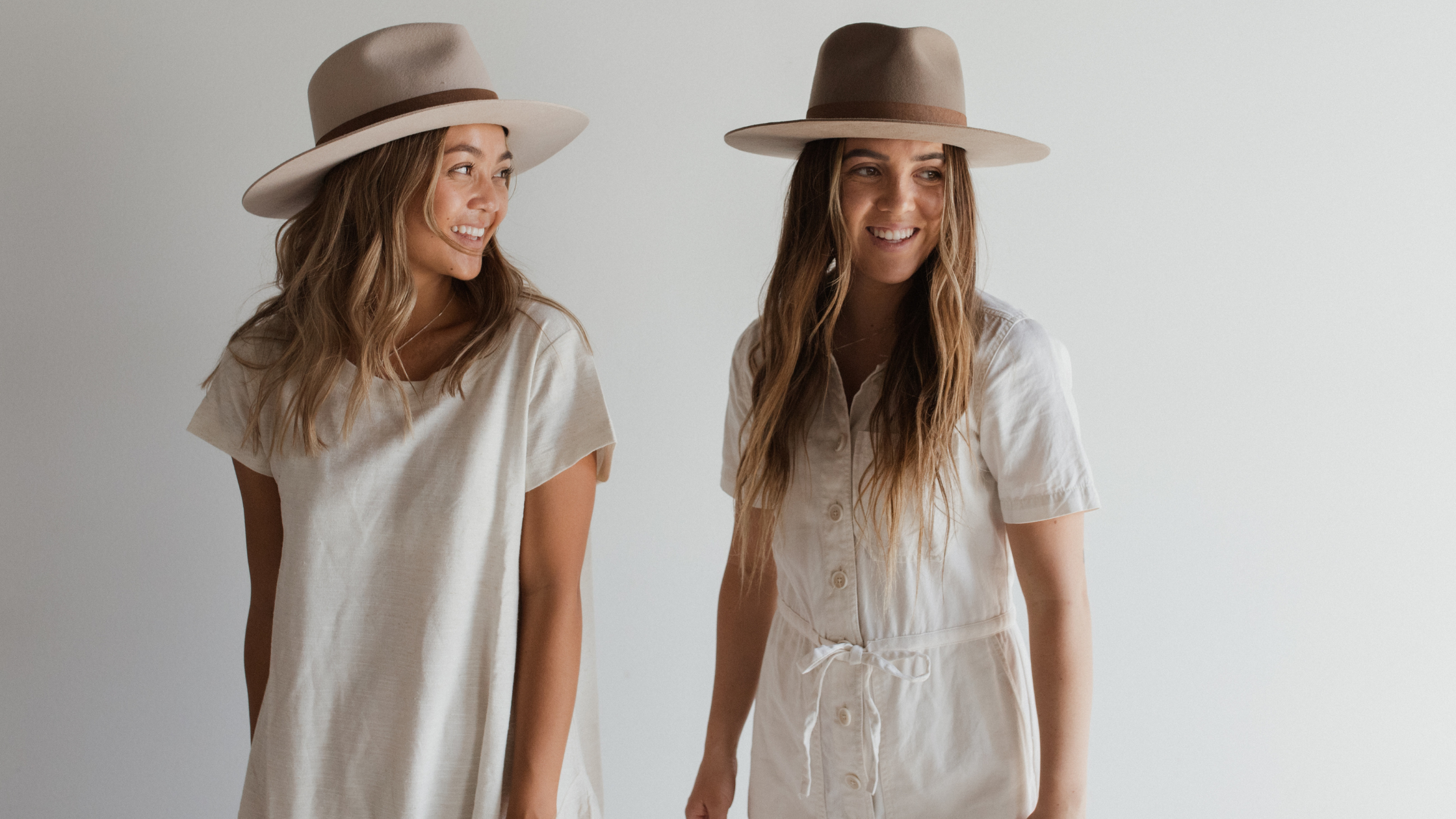 two women in fedora hats