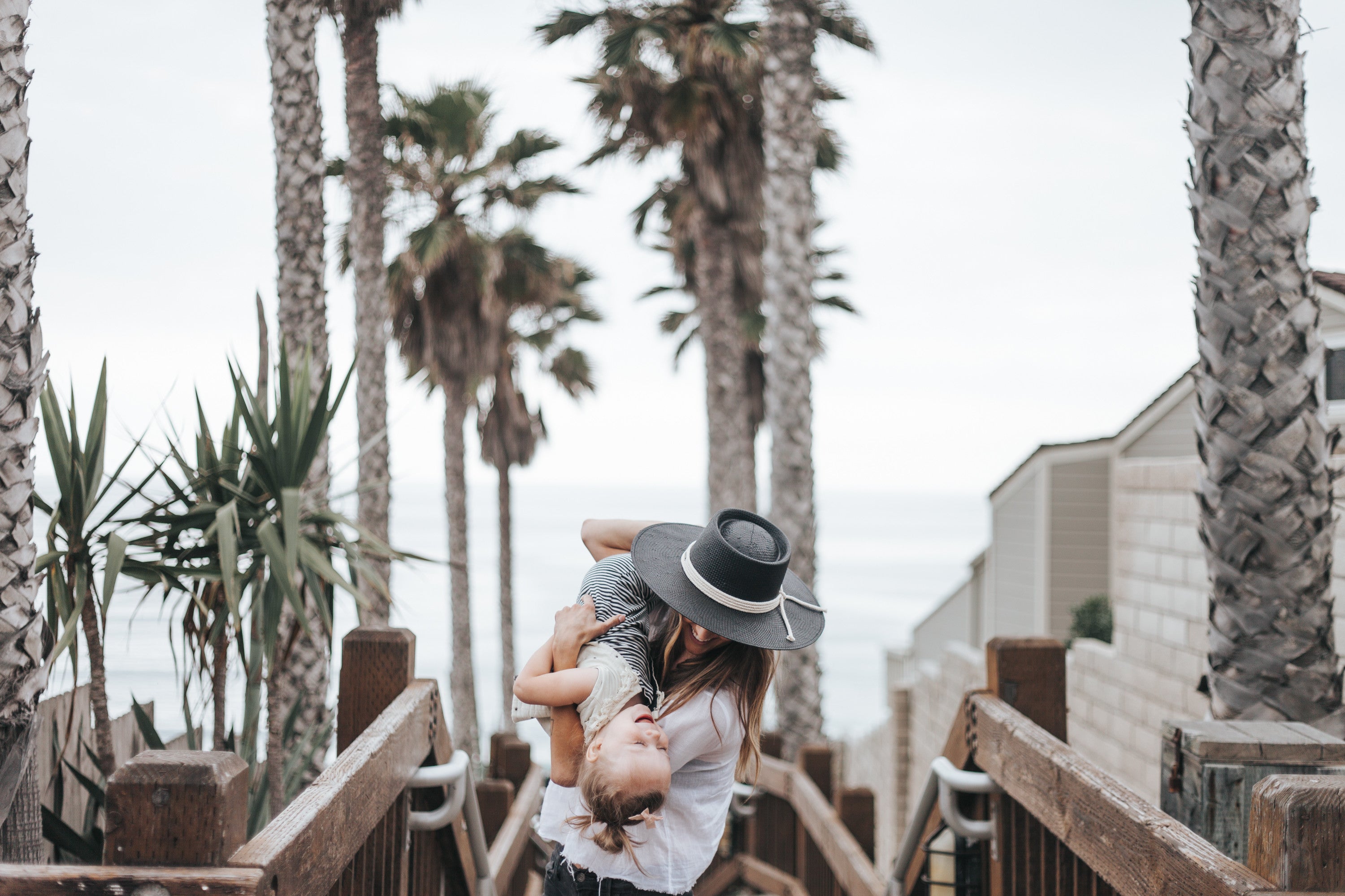 woman holding child palm trees