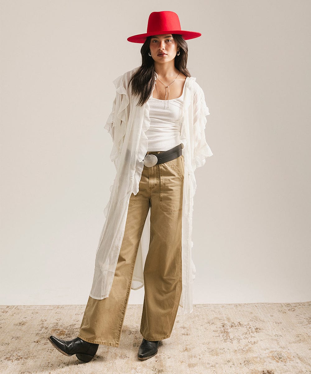 Woman wearing a red hat, white shirt, beige pants, and black shoes on a plain background #color_cherry red