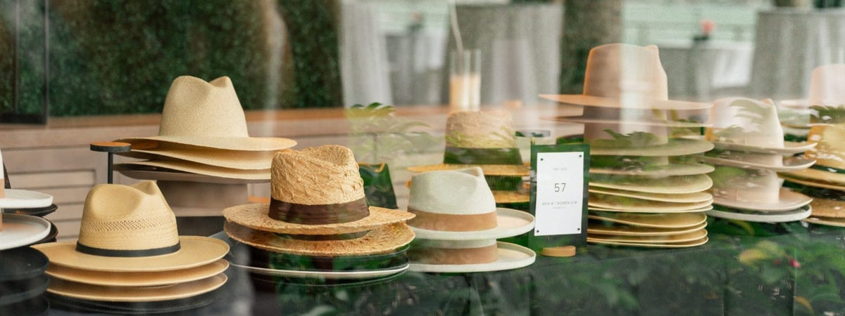 Collection of hats displayed on a table with a blurred background at a custom hat bar event.