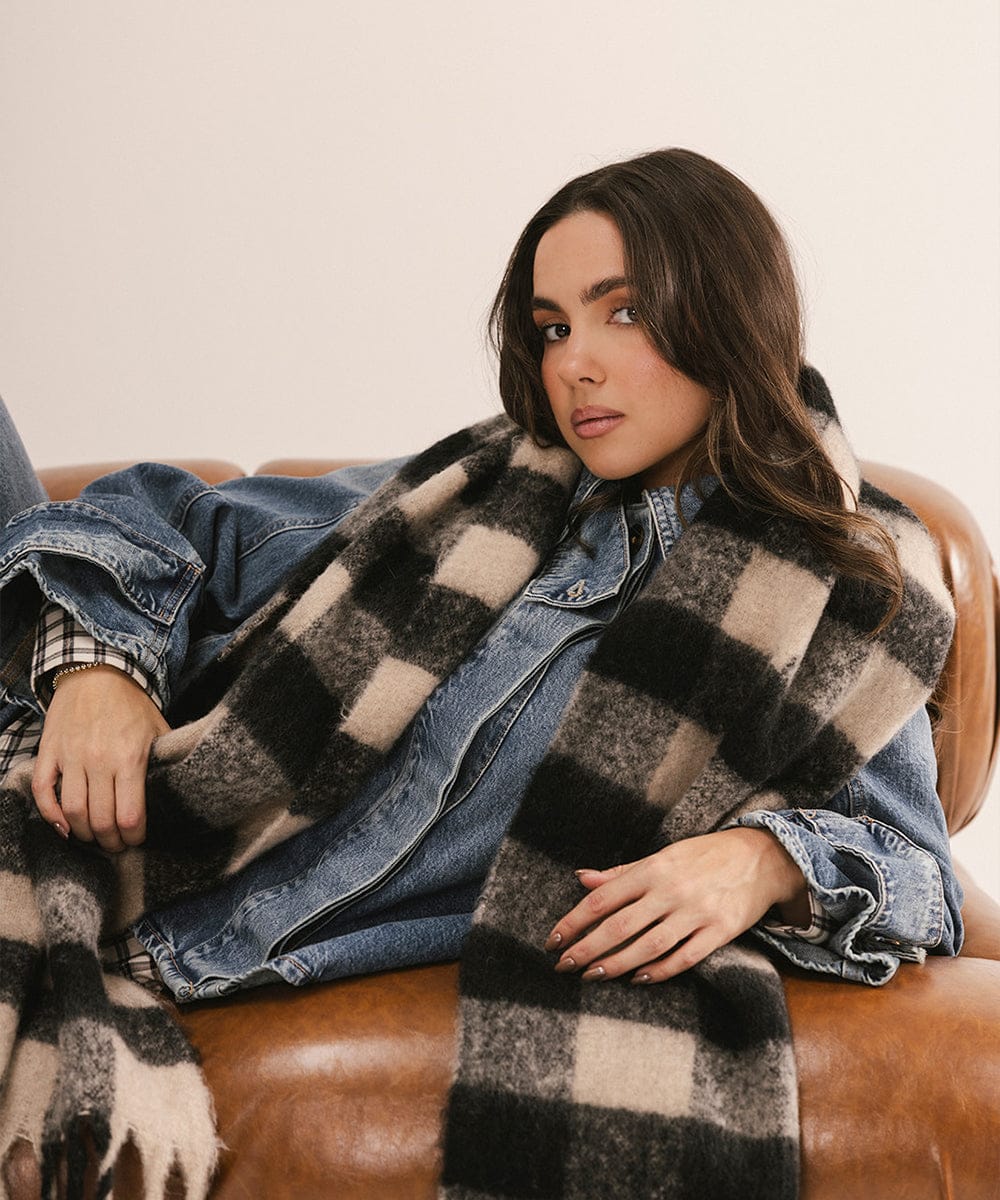 Woman sitting on a couch wearing a plaid coat and denim jacket. #color_Black - Cream Buffalo Check