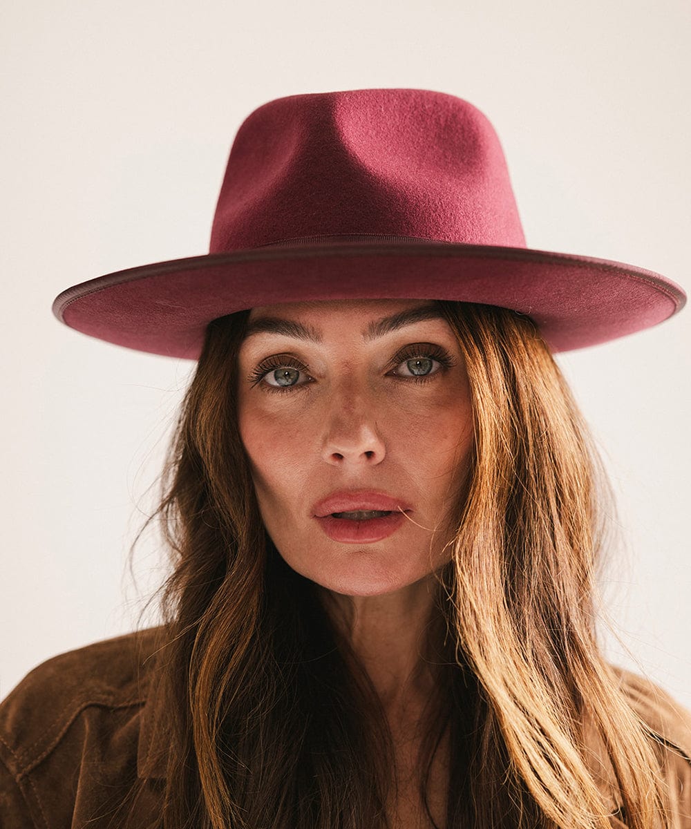 Woman wearing a maroon hat with a plain background #color_merlot