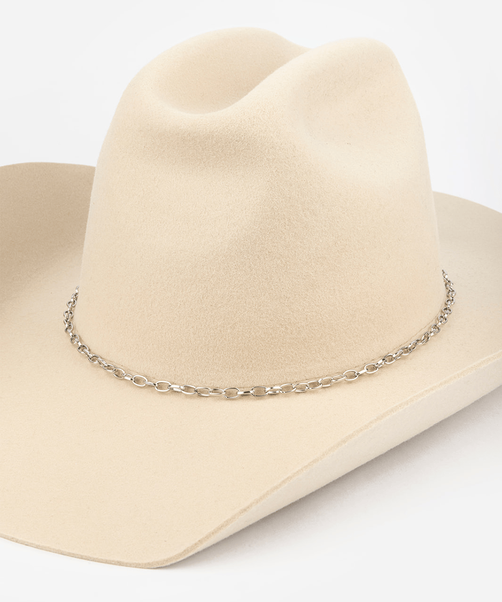 Silver chain necklace draped over a beige cowboy hat on a white background #color_silver