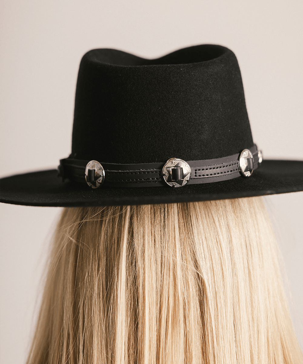 Black fedora hat with decorative concho band on a neutral background #color_black