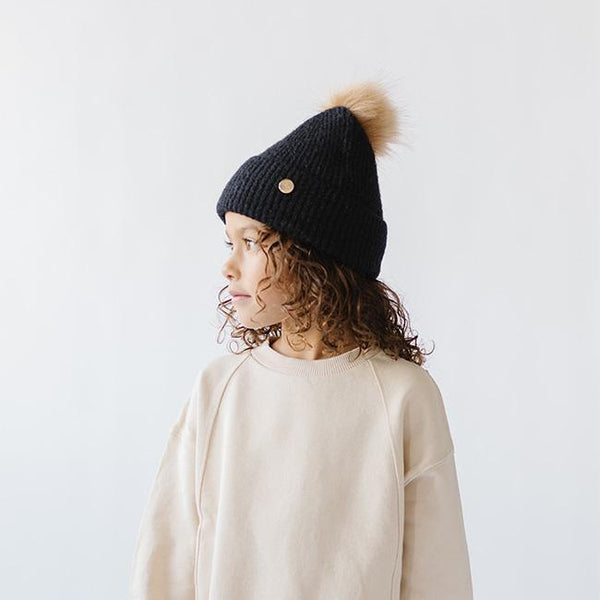 Gigi Pip beanies for kids - Milo Beanie - soft knit ribbers kid's beanie featuring a fold up brim with a rose gold Gigi Pip logo pin on the side of the fold and a pom pom on the center of the crown [midnight]