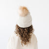 Gigi Pip beanies for kids - Milo Beanie - soft knit ribbers kid's beanie featuring a fold up brim with a rose gold Gigi Pip logo pin on the side of the fold and a pom pom on the center of the crown [oatmeal]
