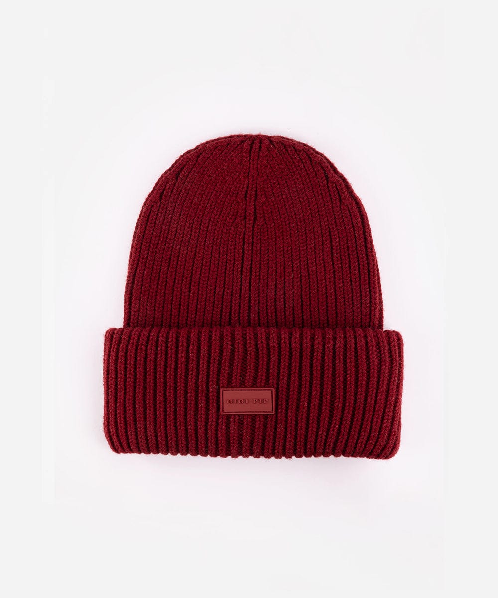Red knit beanie with a small patch on a white background #color_burgundy