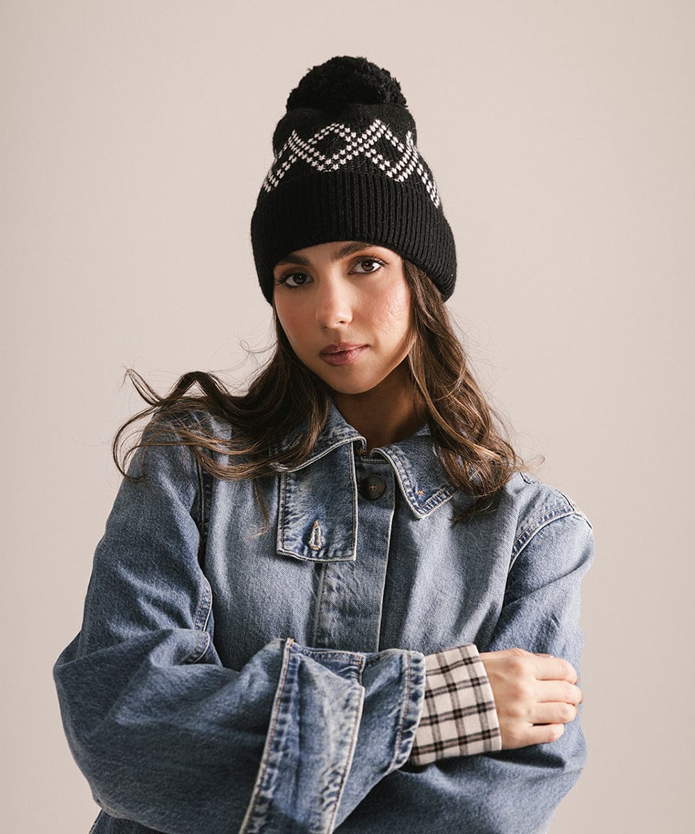 Woman wearing a black beanie with a pattern and a denim jacket on a beige background #color_black
