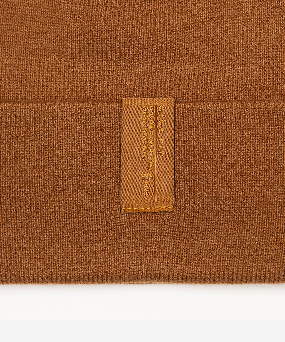 Close-up of a brown fabric with a brand label on a white background #color_cocoa