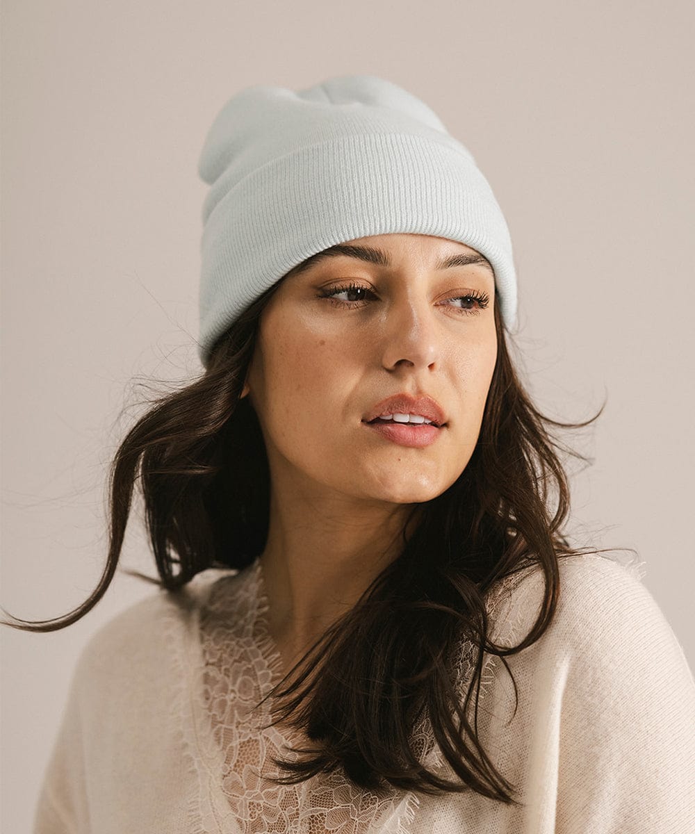 Woman wearing a light blue beanie against a plain background #color_sky blue