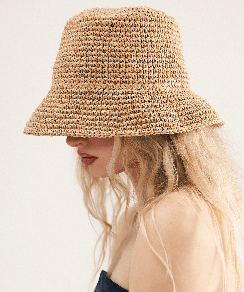 Person wearing a brown crochet packable bucket hat made from paper straw, displayed against a white background. #color_natural brown