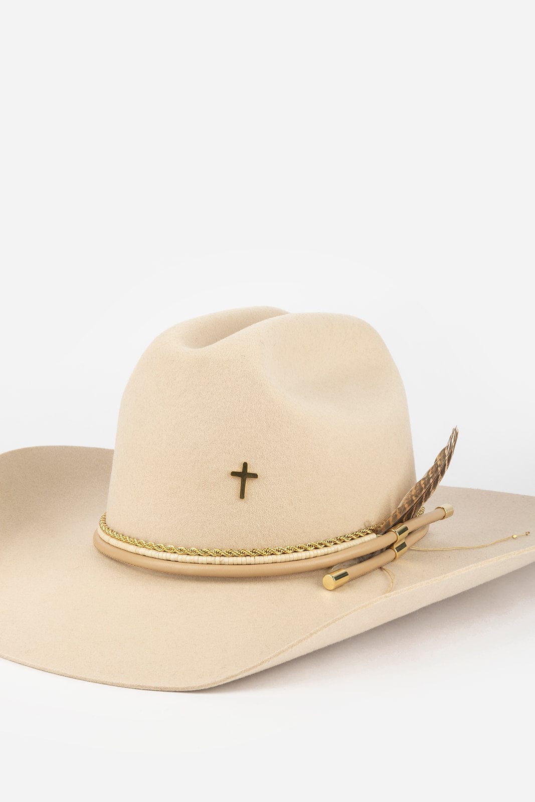 Beige cowboy hat with decorative cross and feather on a white background #color_gold