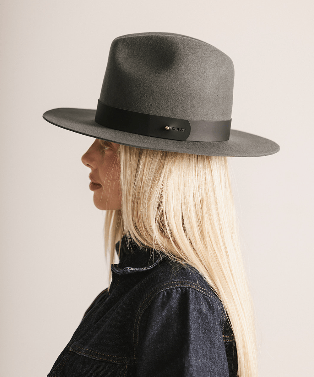 Woman wearing a grey fedora hat on a white background #color_dark grey