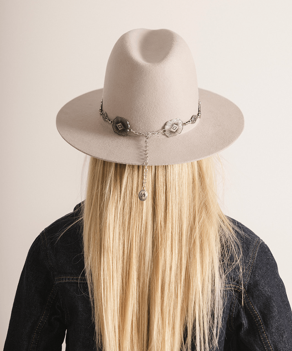 Woman wearing an ivory colored hat against a white background #color_ivory