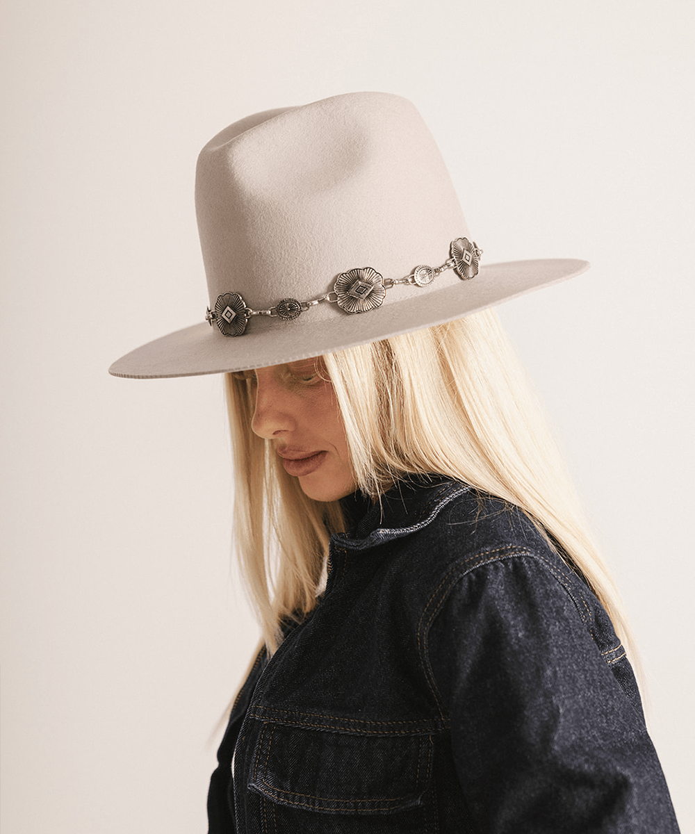 Woman wearing an ivory colored hat against a white background #color_ivory