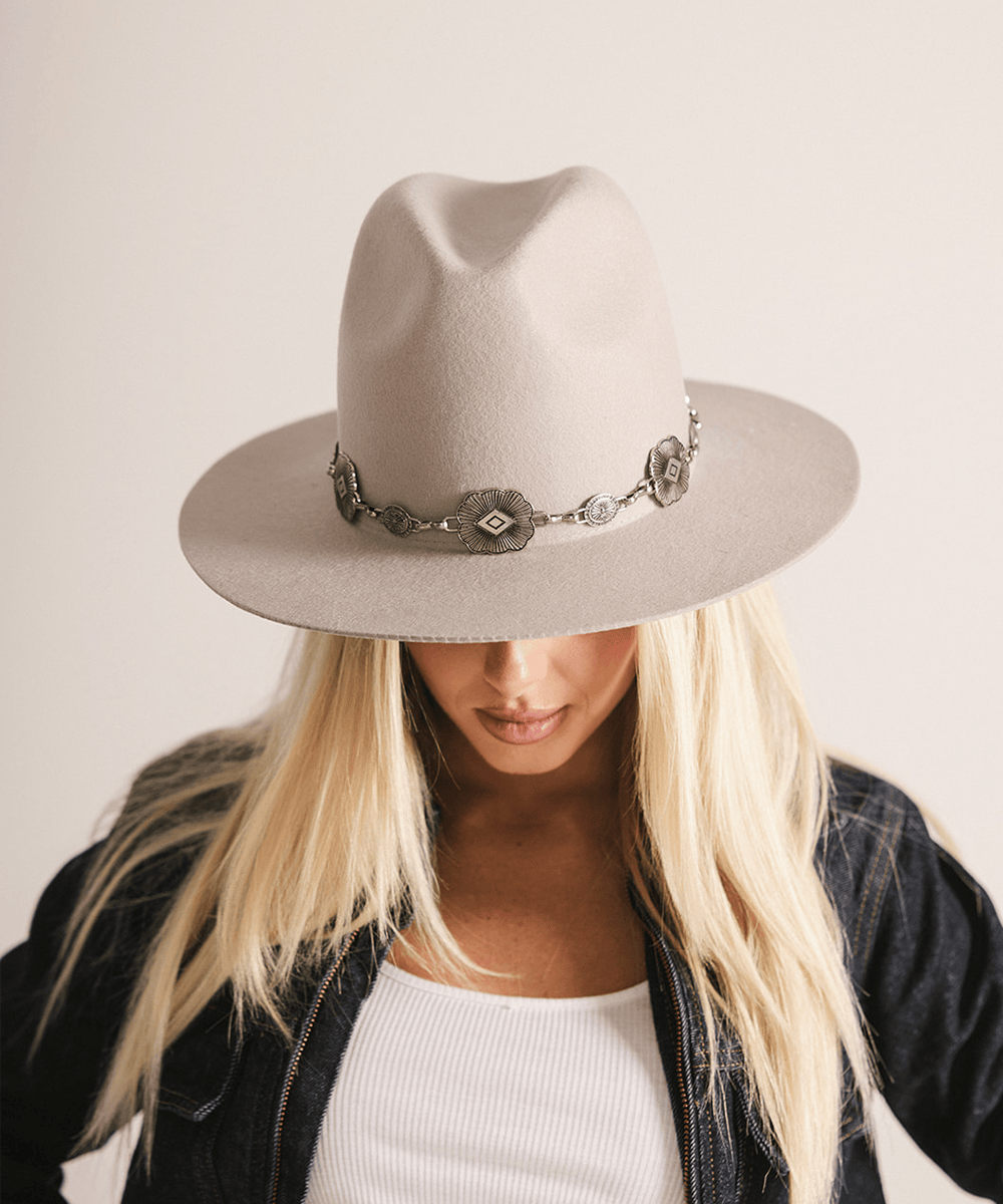 Woman wearing an ivory colored hat against a white background #color_ivory