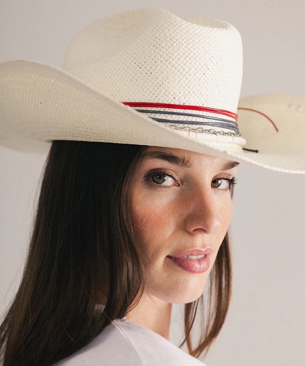 Woman wearing a cowboy hat with decorative bands in a plain background #color_natural white