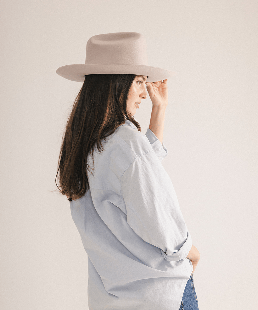 Woman wearing a western felt hat on a white background #color_ivory