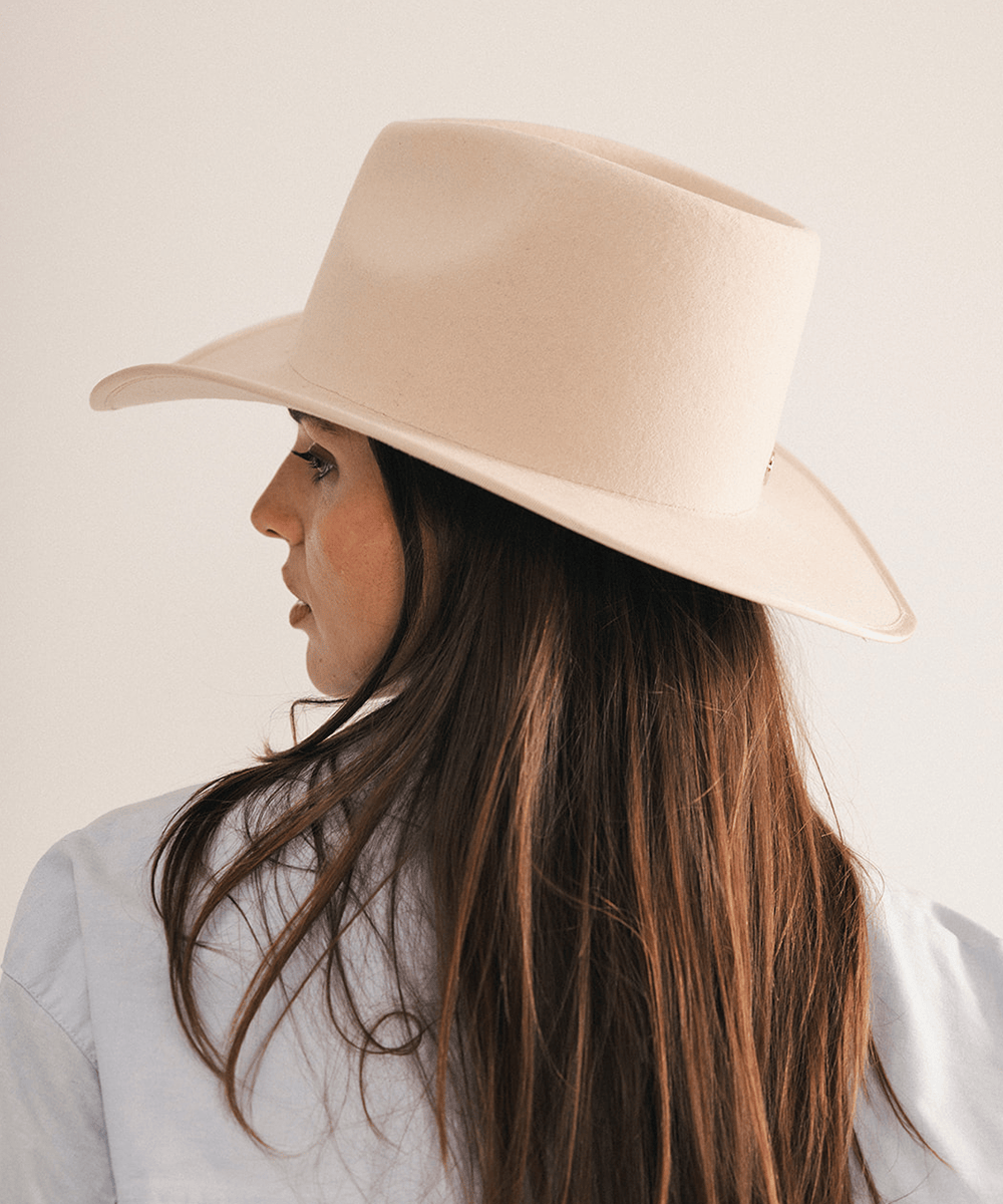 Woman wearing a beige felt hat on a white background #color_cream