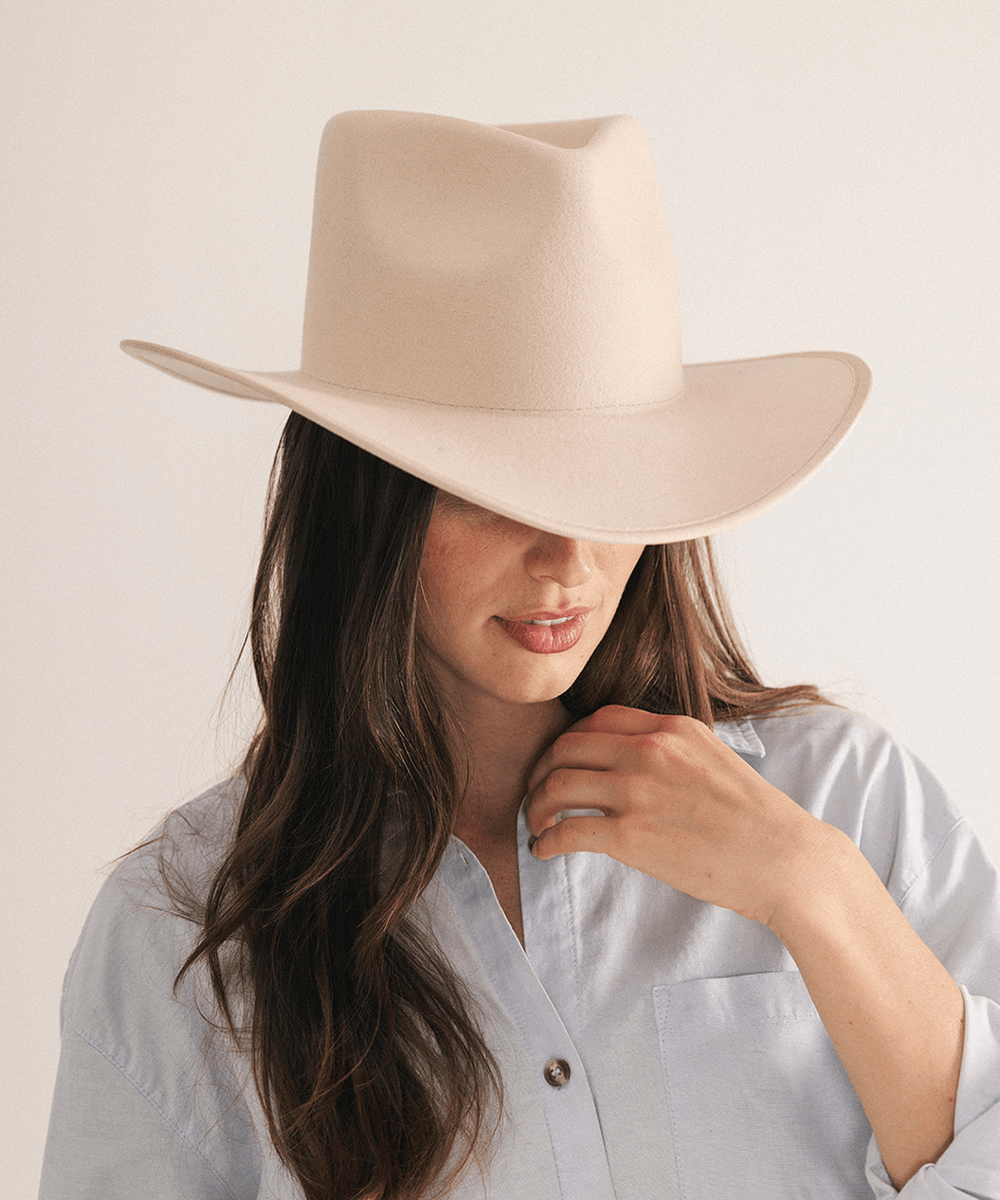 Woman wearing a beige felt hat on a white background #color_cream