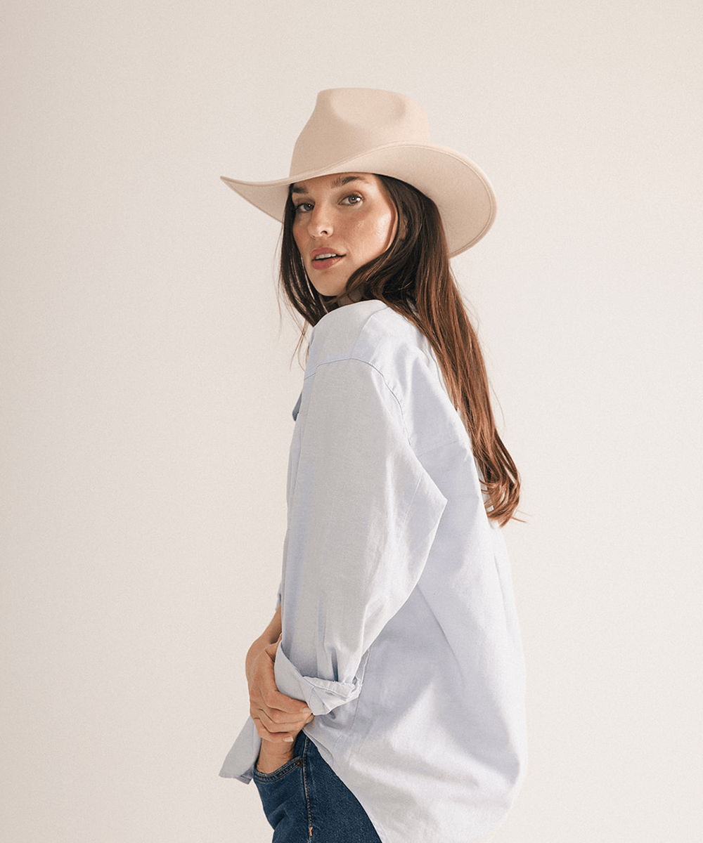 Woman wearing a beige felt hat on a white background #color_cream