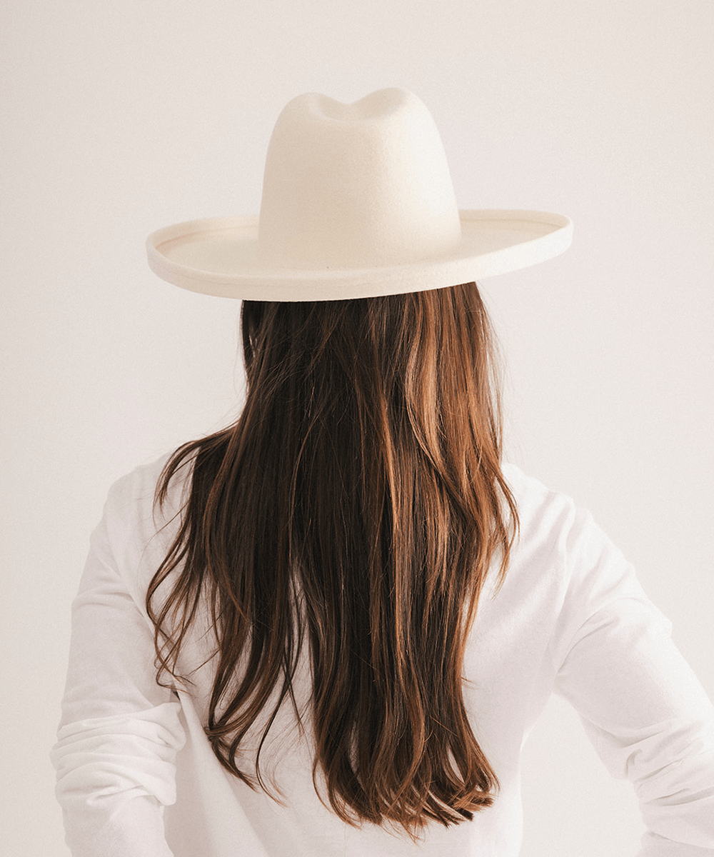 Woman wearing a white pencil brim felt fedora hat on a white background #color_off white