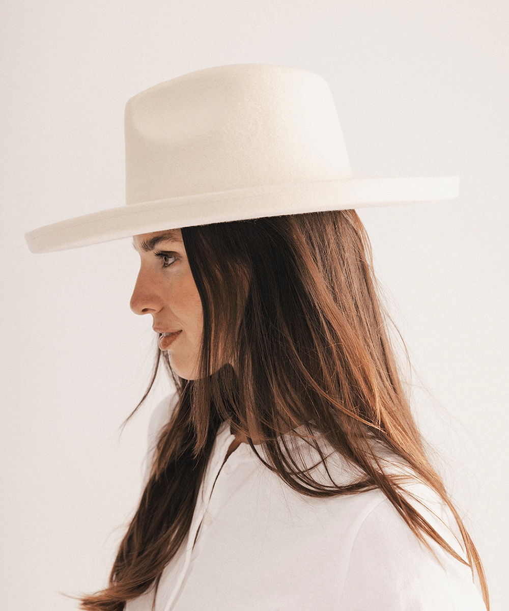 Woman wearing a white pencil brim felt fedora hat on a white background #color_off white