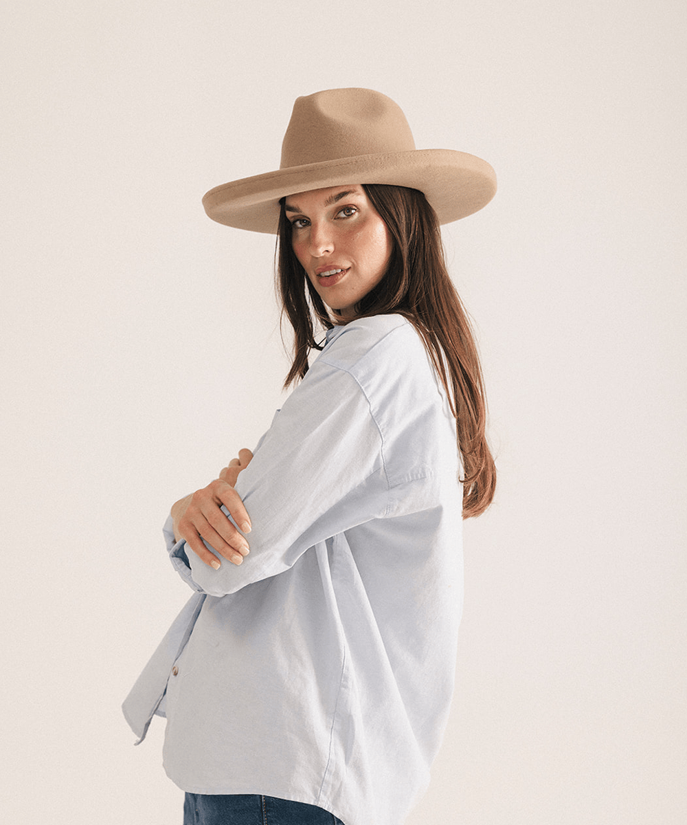 Woman wearing a tan pencil brim felt fedora hat on a white background #color_tan