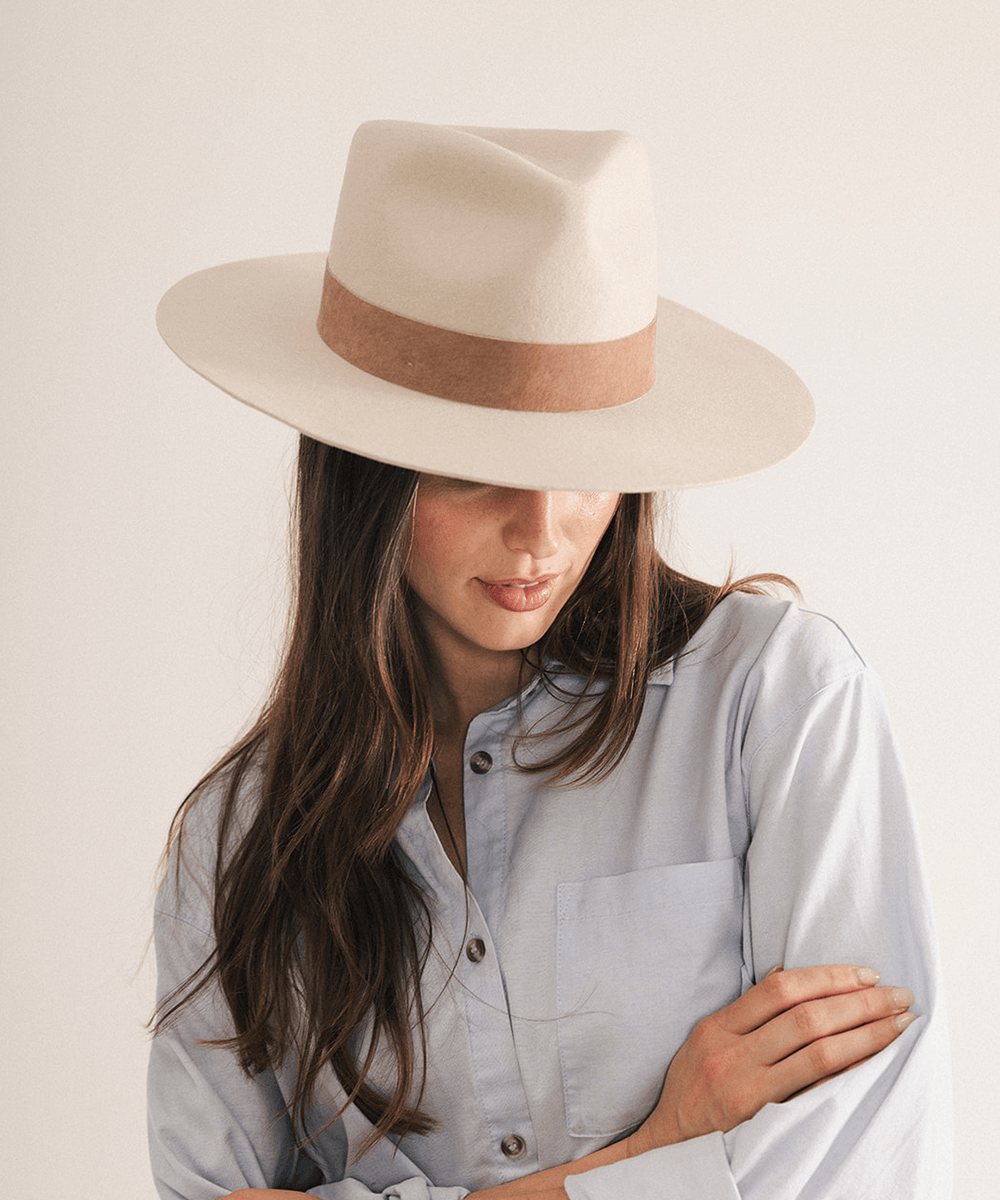 Woman wearing a fedora hat with a brown band on a white background #color_ivory