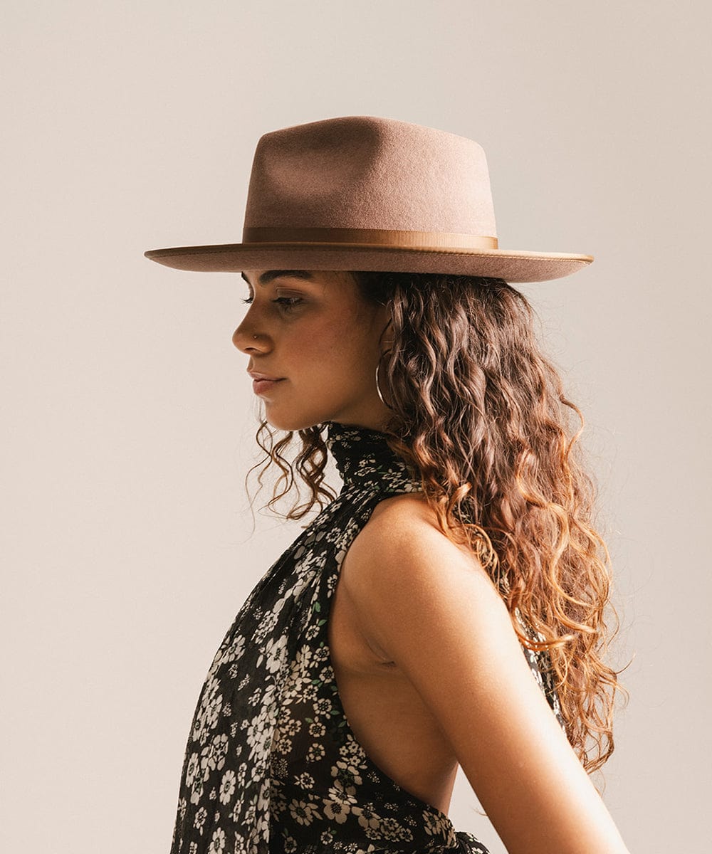Woman wearing a brown hat against a plain background #color_chocolate