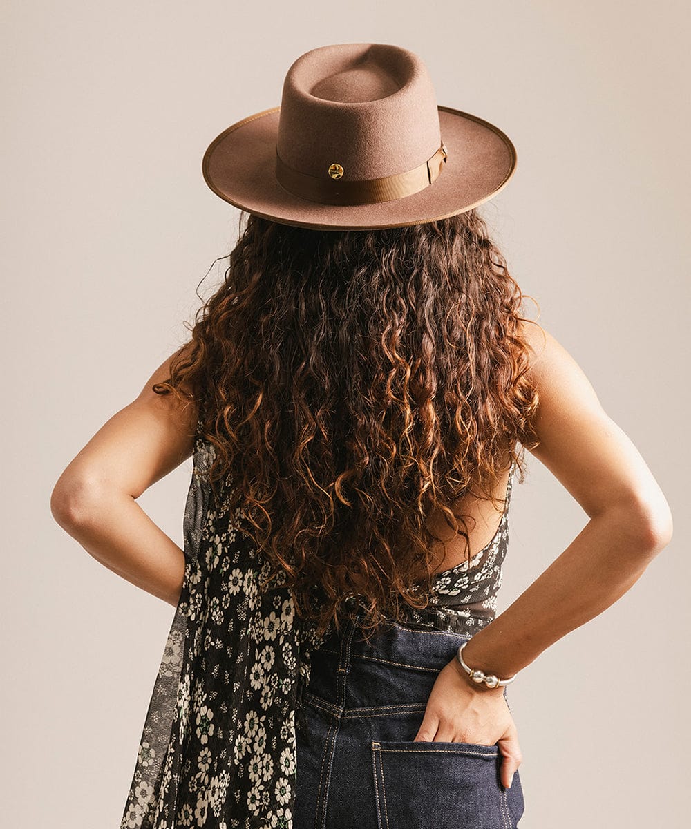 Person wearing a brown hat with a neutral background #color_chocolate
