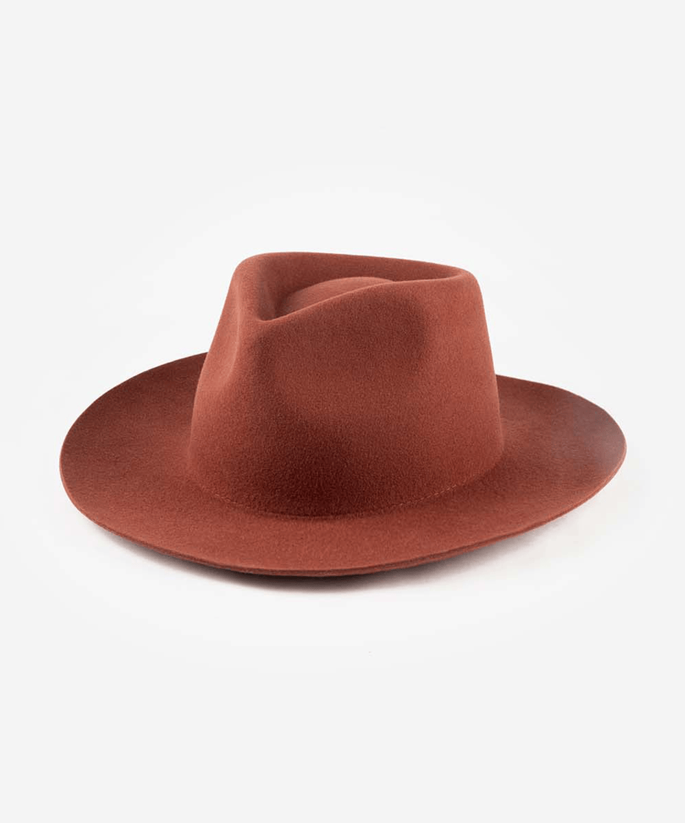 A rust-colored felt fedora hat with a wide brim, photographed from a side profile against a clean white background #color_rusty red