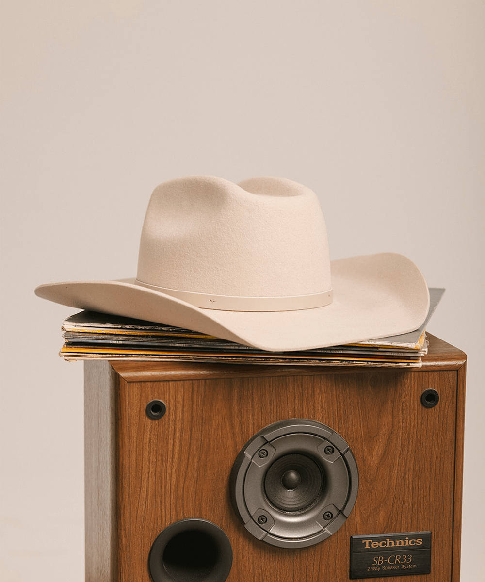 Beige cowboy hat on a Technics speaker with a beige background #color_cream