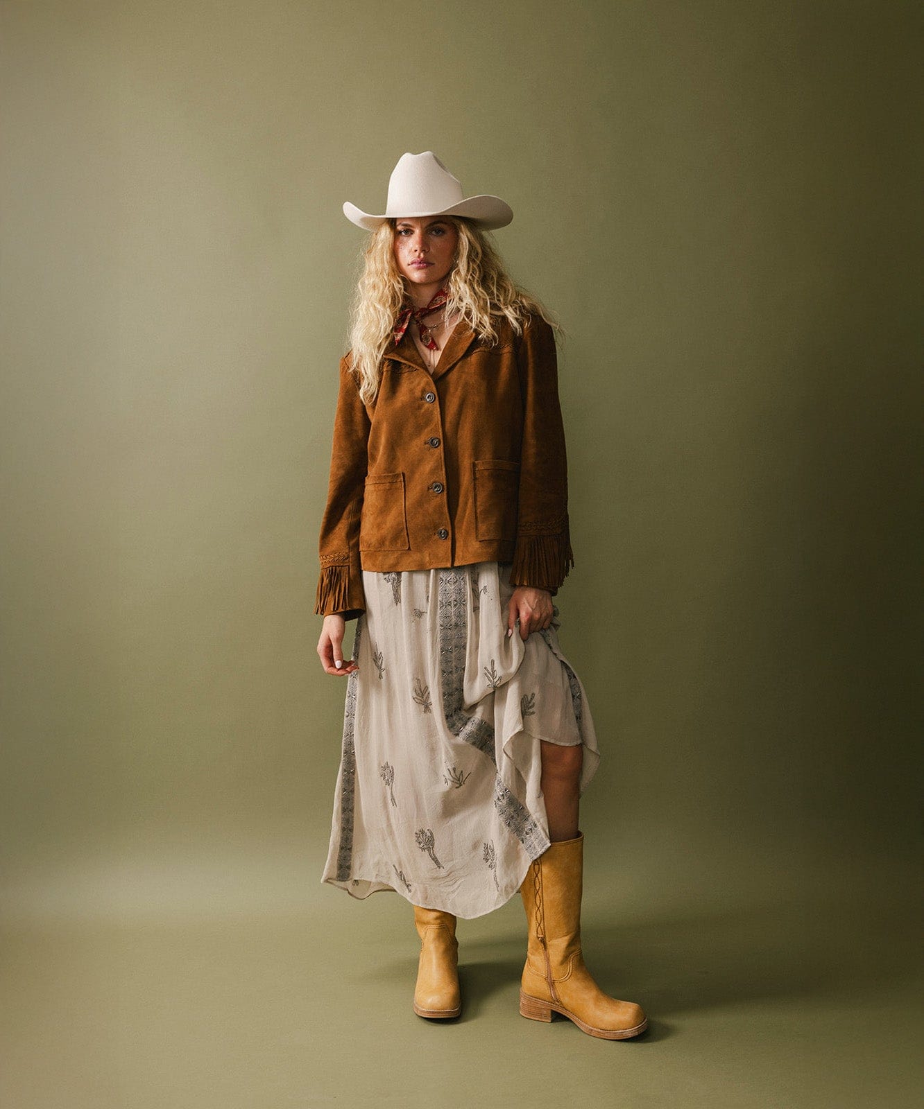 Woman wearing a brown jacket, white hat, and yellow boots against a green background #color_off white