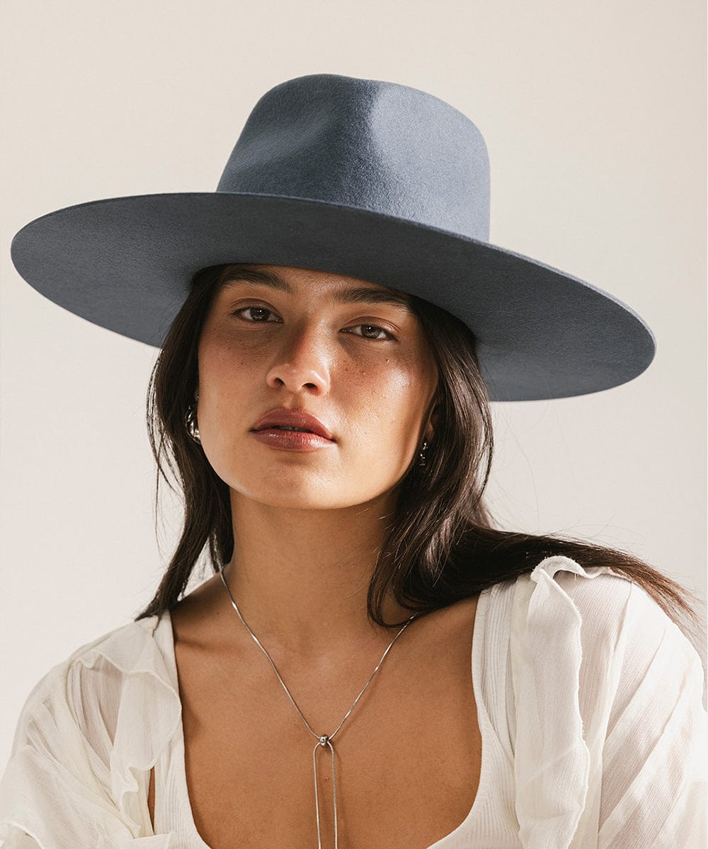 Woman wearing a wide-brimmed blue hat against a plain background
#color_vintage blue
