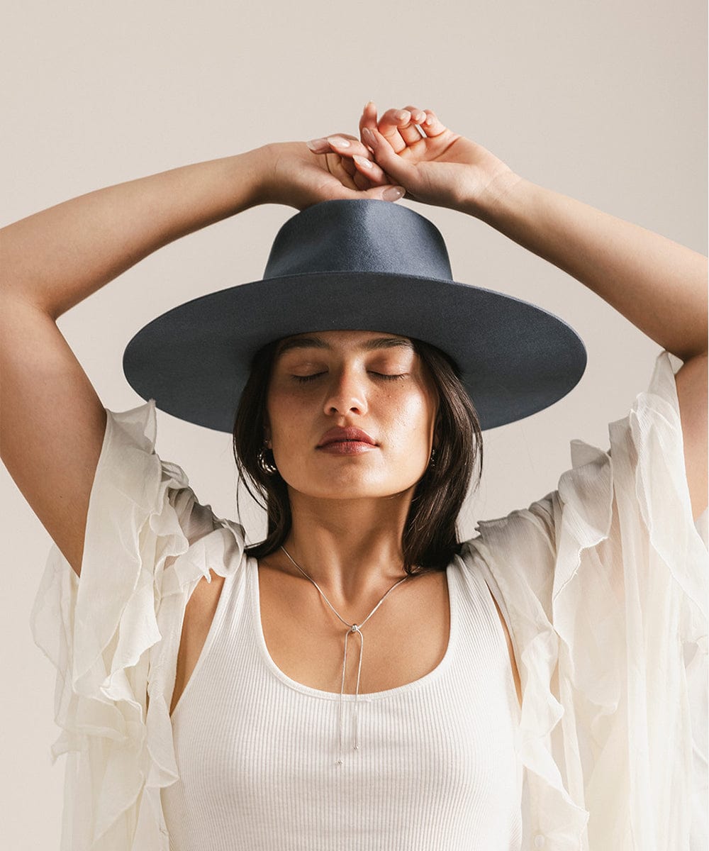 Woman wearing a dark blue hat with a plain background #color_vintage blue