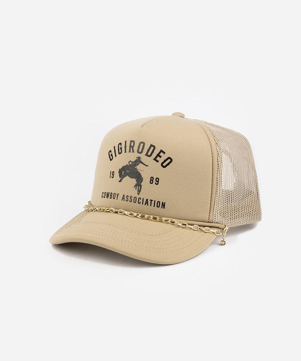 Beige trucker hat with chain and 'Gigi Rodeo' logo on a white background #color_gold