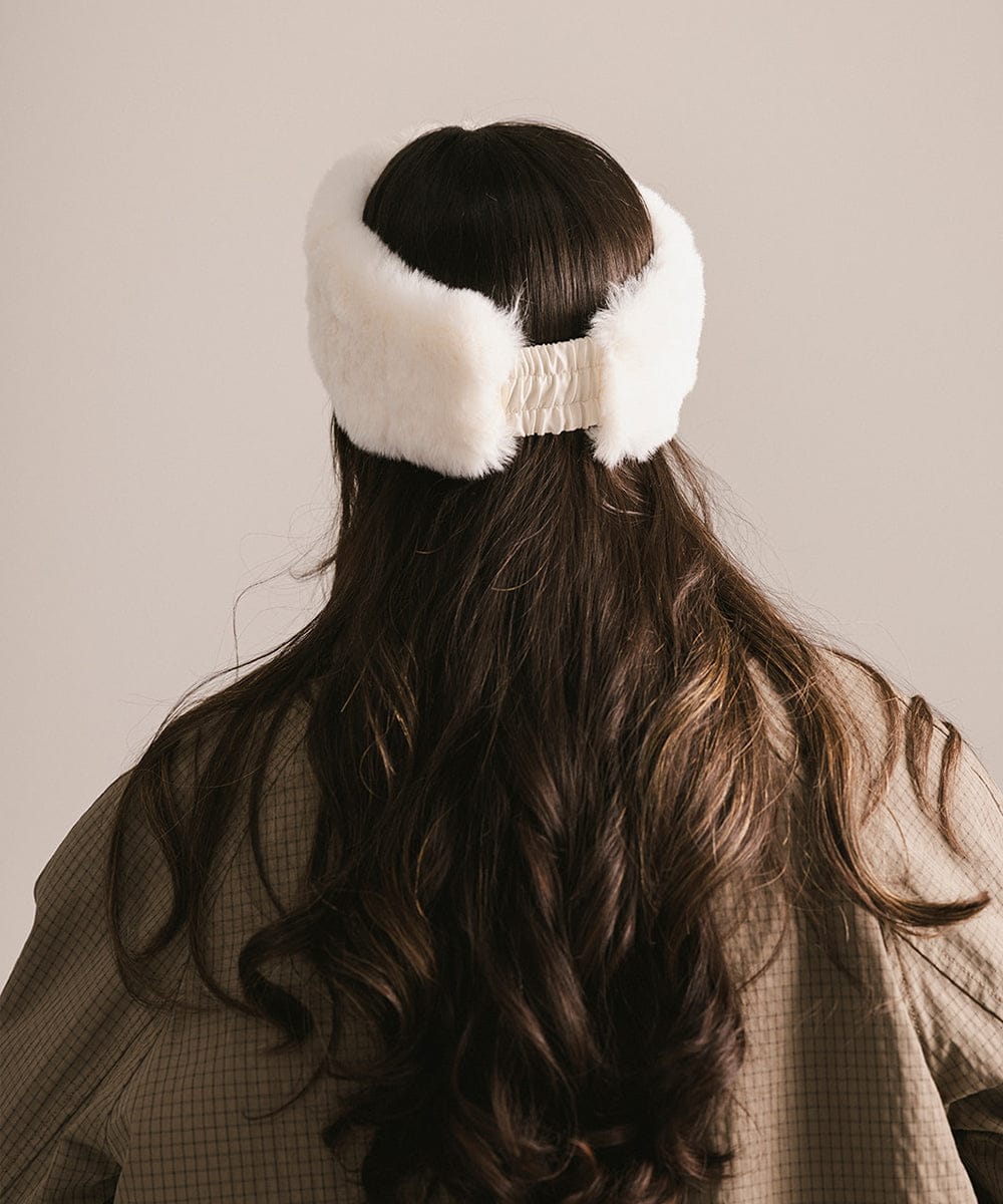 Person wearing a white fur headband with a neutral background #color_winter white
