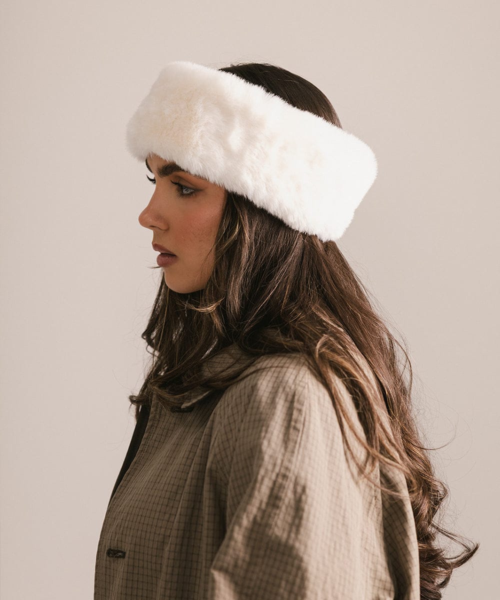 Woman wearing a white fur headband against a neutral background #color_winter white