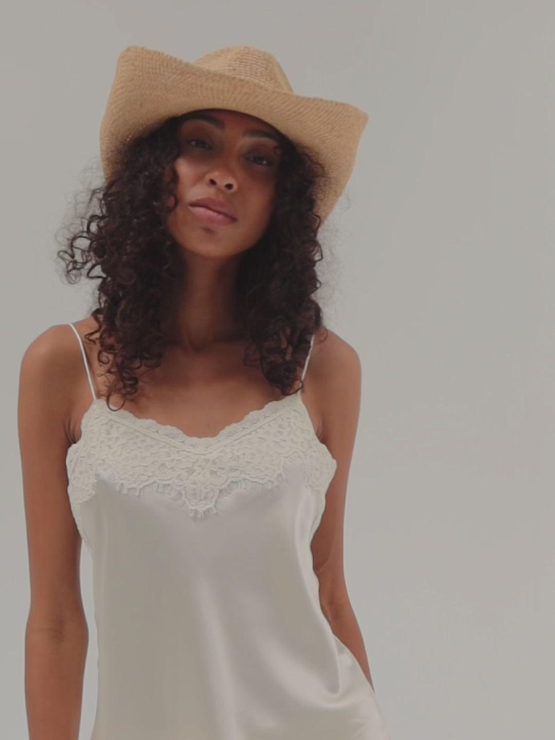 Woman wearing a straw hat against a plain background #color_natural