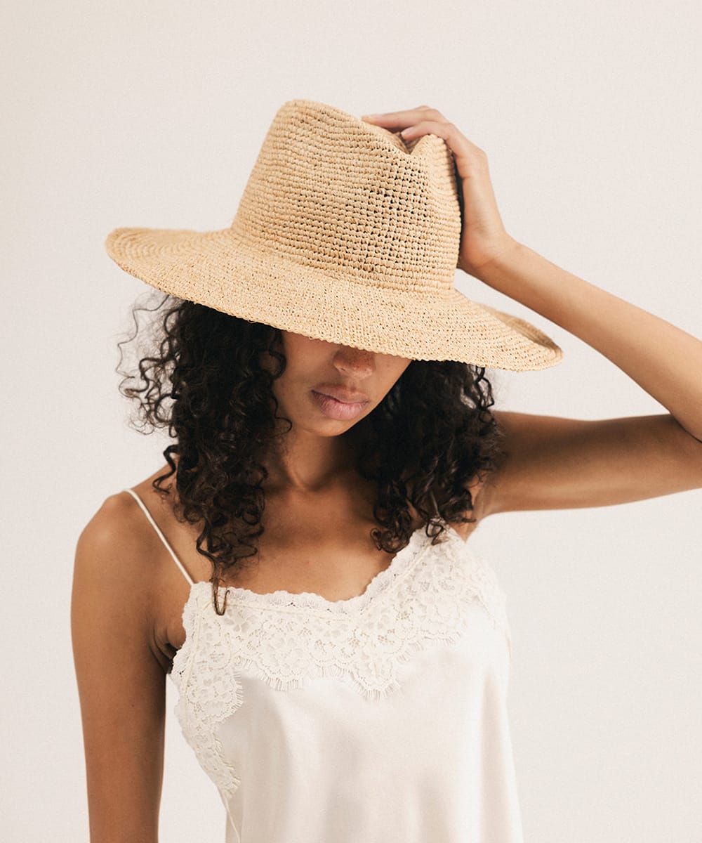 Woman wearing a straw hat against a plain background #color_natural