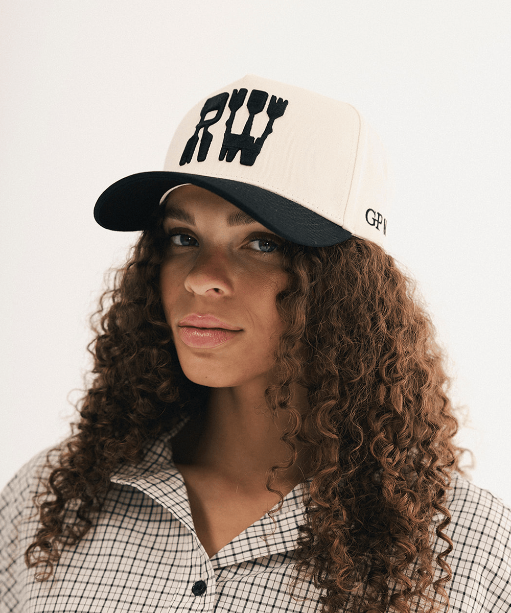 Woman wearing a black and white baseball cap and plaid shirt in a white background #color_cream - black