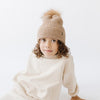 Gigi Pip beanies for kids - Milo Beanie - soft knit ribbers kid's beanie featuring a fold up brim with a rose gold Gigi Pip logo pin on the side of the fold and a pom pom on the center of the crown [camel]