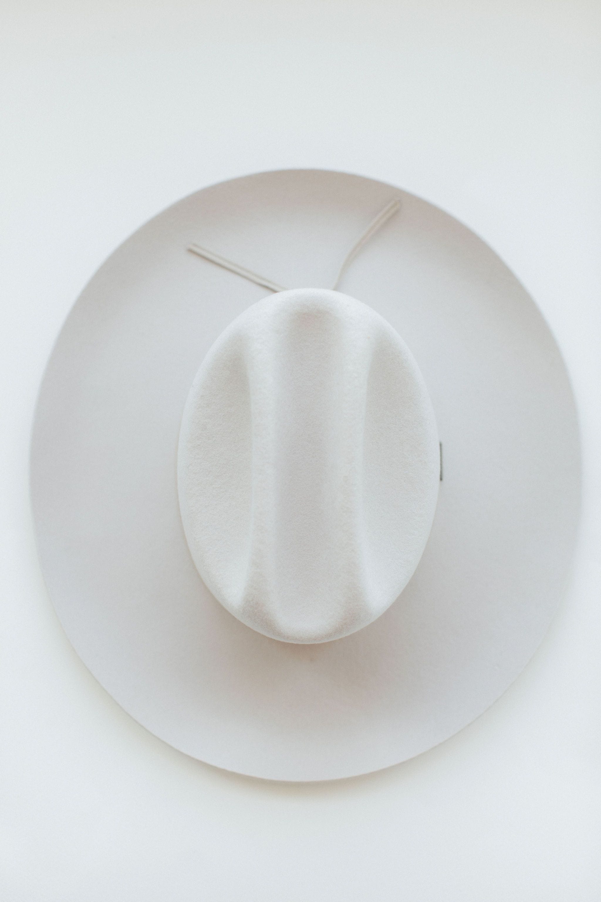 An ivory colored cowboy hat on a white background #color_ivory