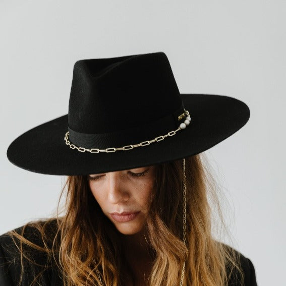 Gigi Pip felt hats for women - Raine Wide Brim Fedora - wide flat brim with a fedora crown, featuring a gold-plated removable paperclip brass chain with three faux pearls and a hand-sewn grosgrain band with the gold Gigi Pip bar around the crown, as well as a removable golden chain chinstrap [black]