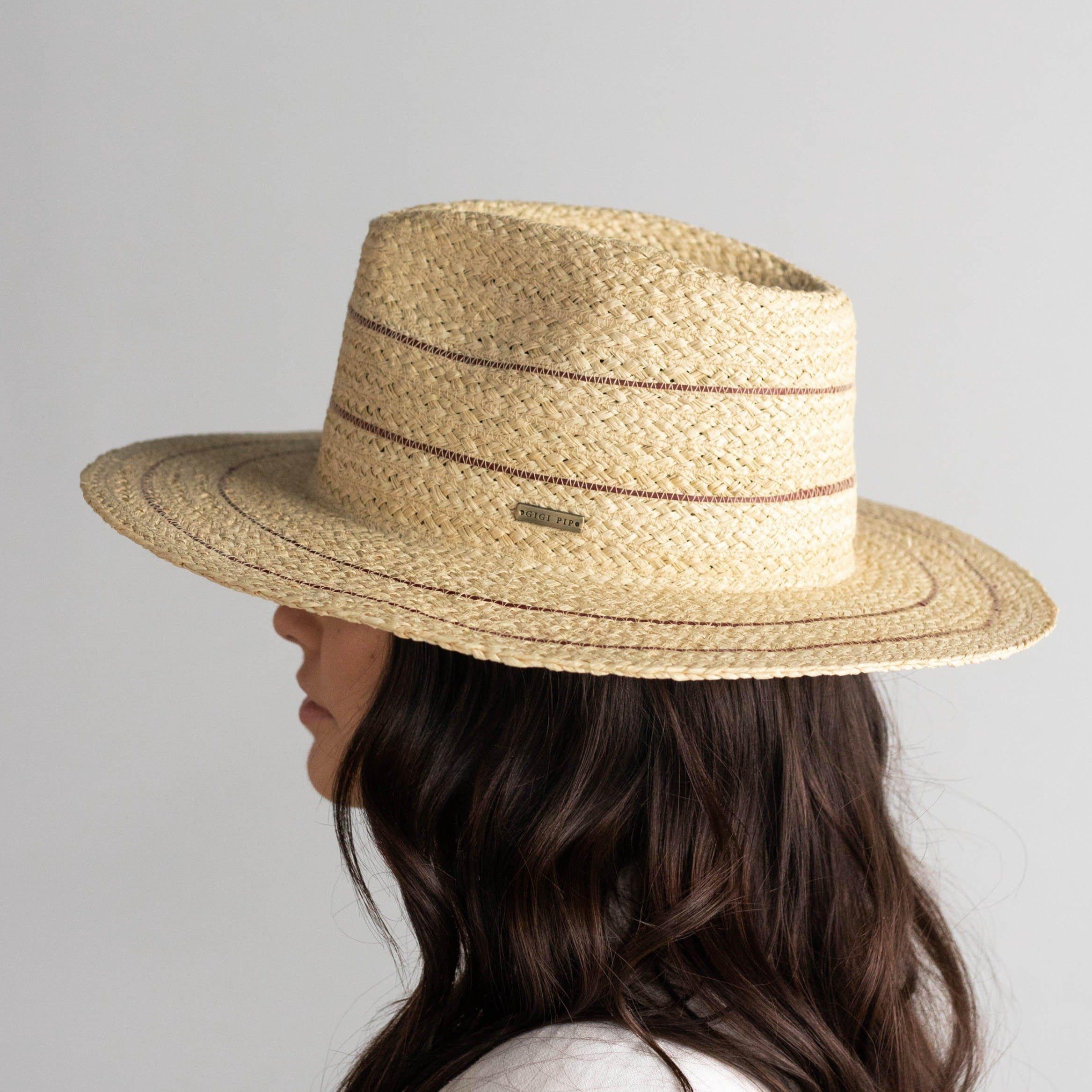 Woman wearing a natural colored straw fedora hat with stripes facing sideways against a plain background #color_natural with stripes